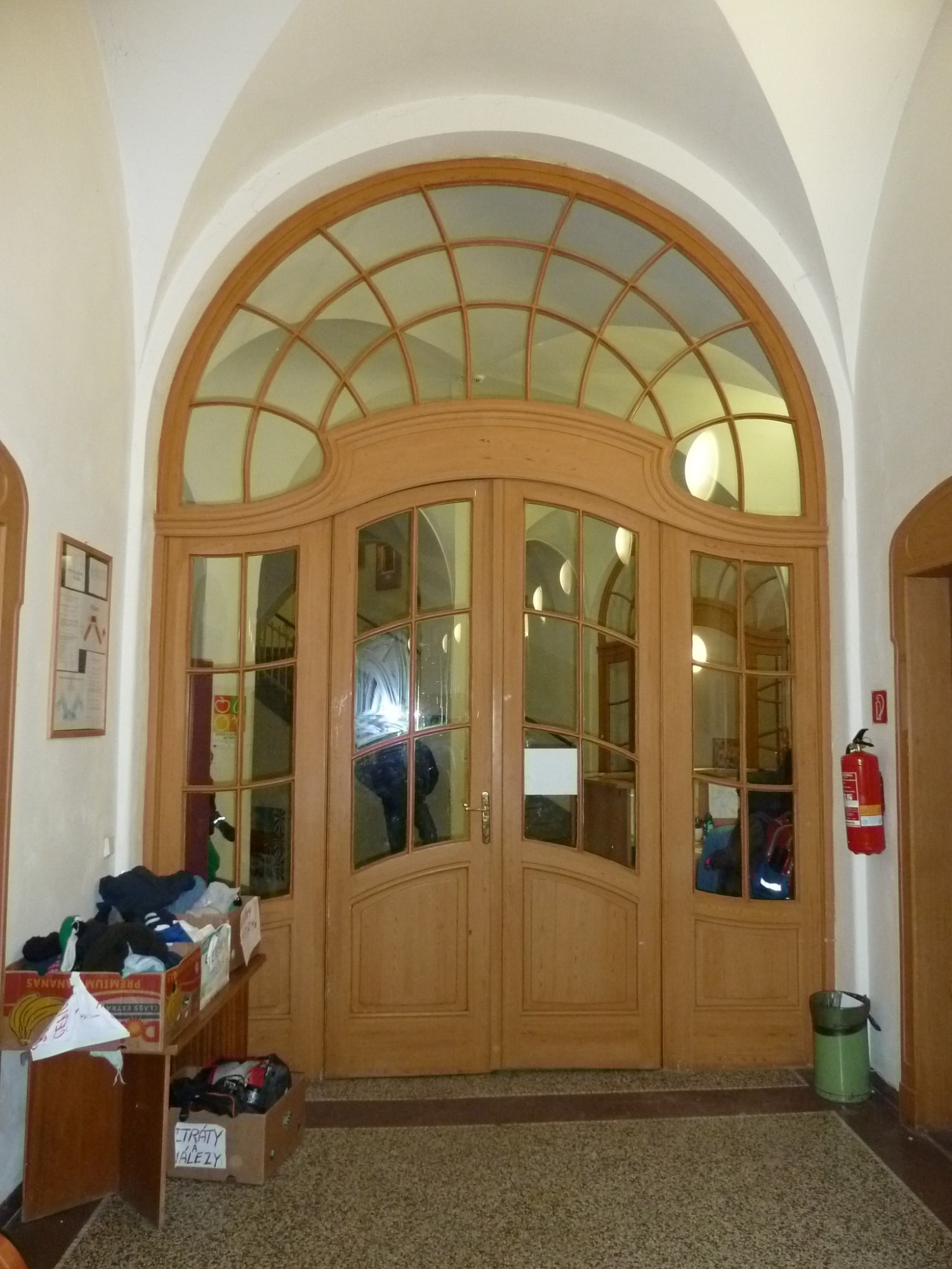 Verglaste Brandwand mit einer Replik historischer Türen in der Eingangshalle einer Schule